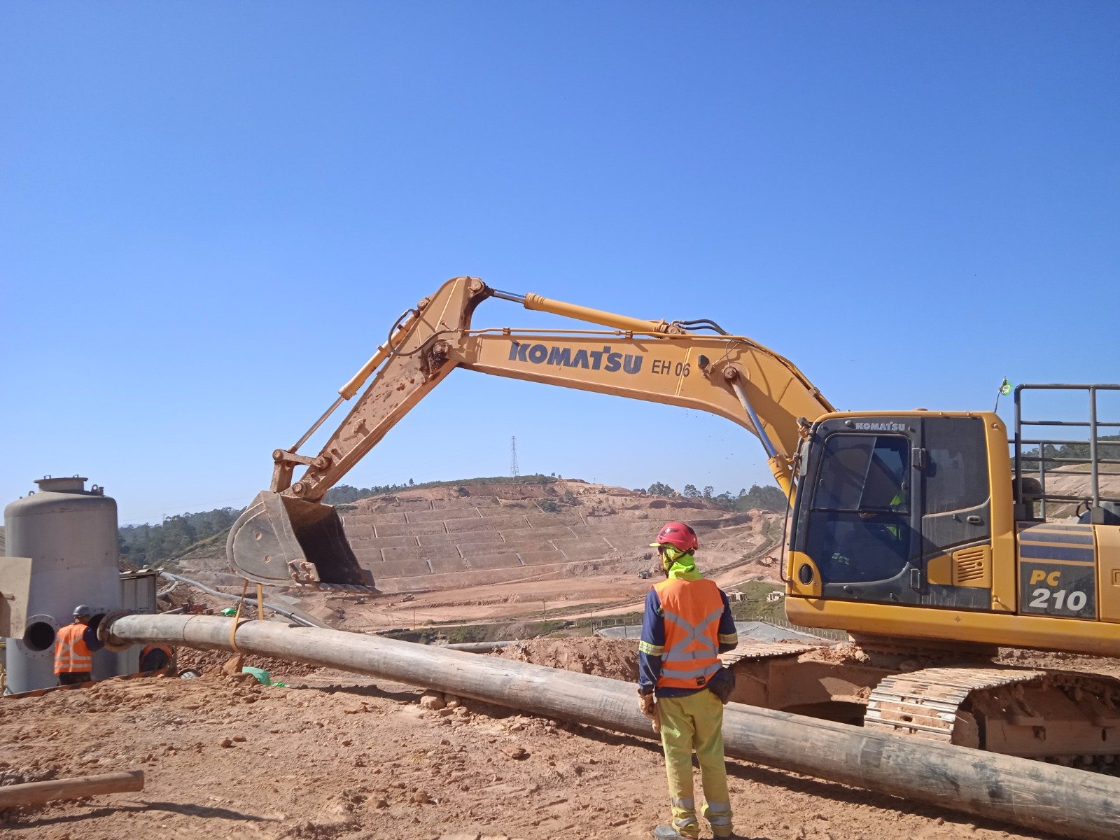 Equipe acompanhando instalação de tubulação de grande diâmetro no aterro